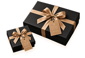 Two dark gift boxes tied with wide gold ribbon