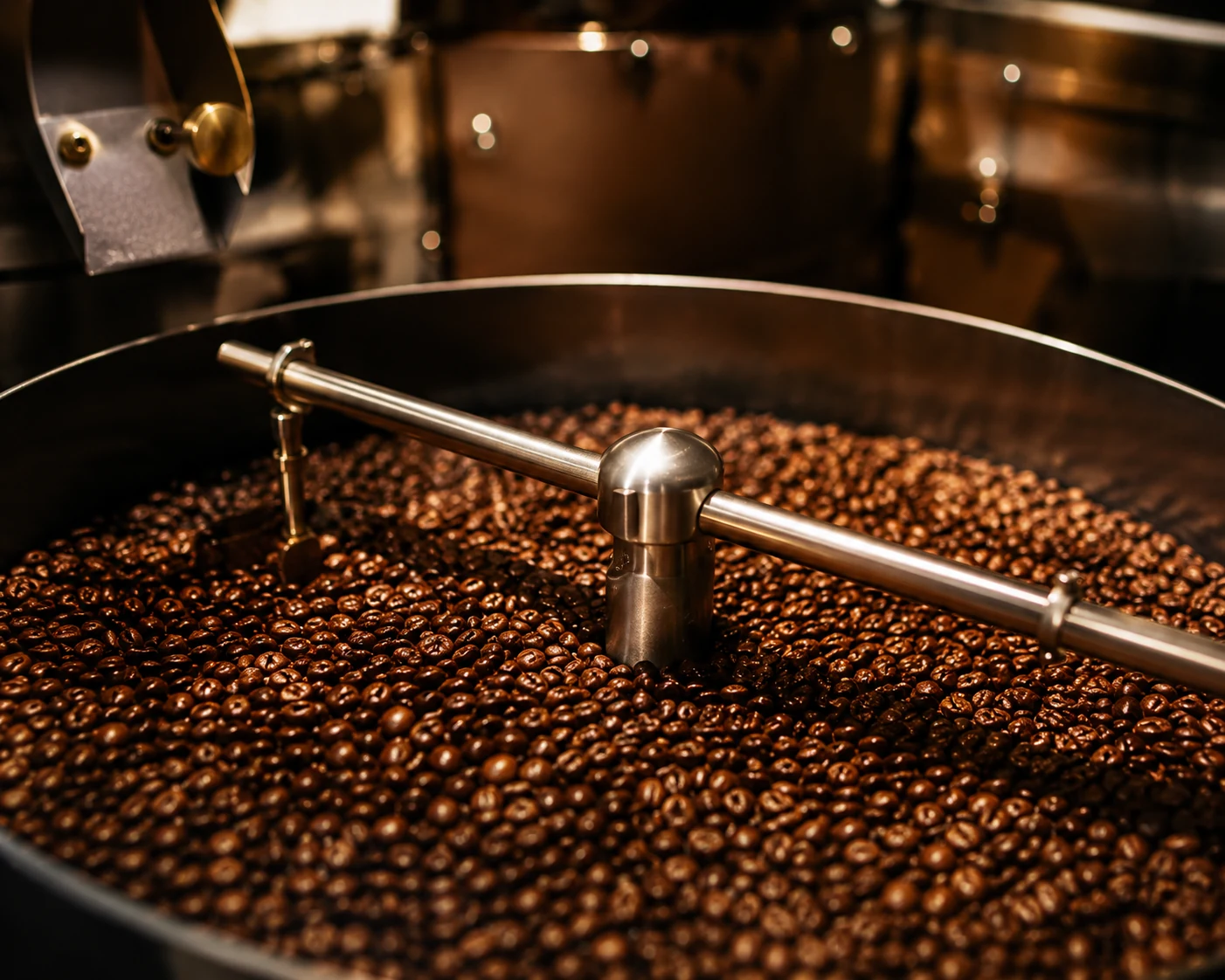 Freshly roasted beans turning under the stirring arm in the drum of a roaster